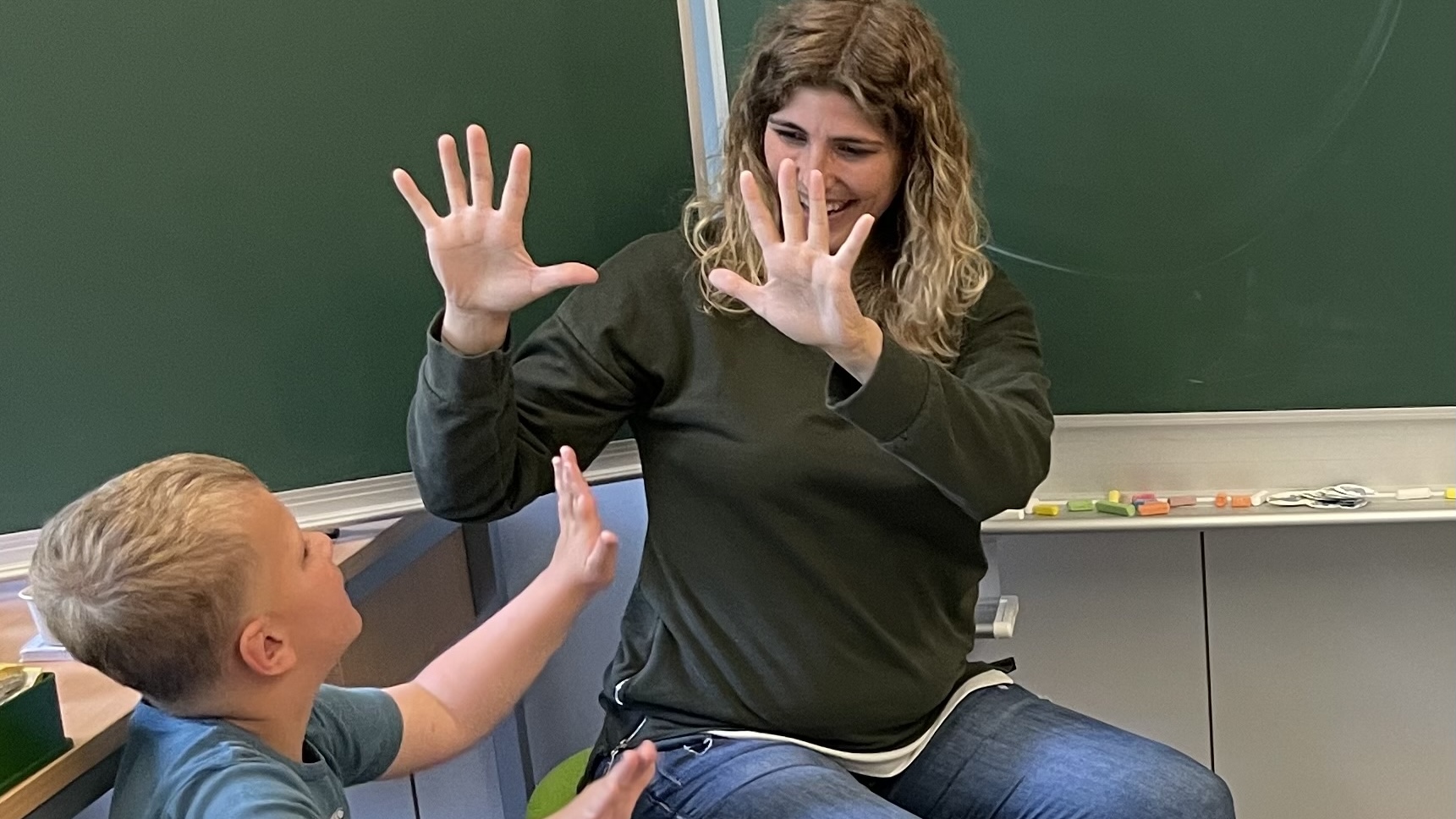 Die Lehrerin zeigt zehn Finger.